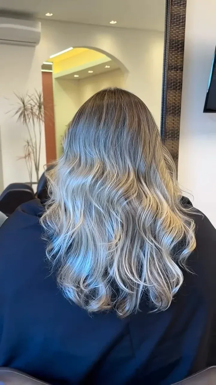 Cabelo loiro com raiz mais escura e ondas, visto de costas